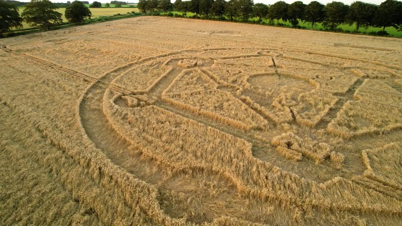 Mysterious Fortnite molecular atom crop circle design sunset wheat field aerial view in Uffcot descending to low shot