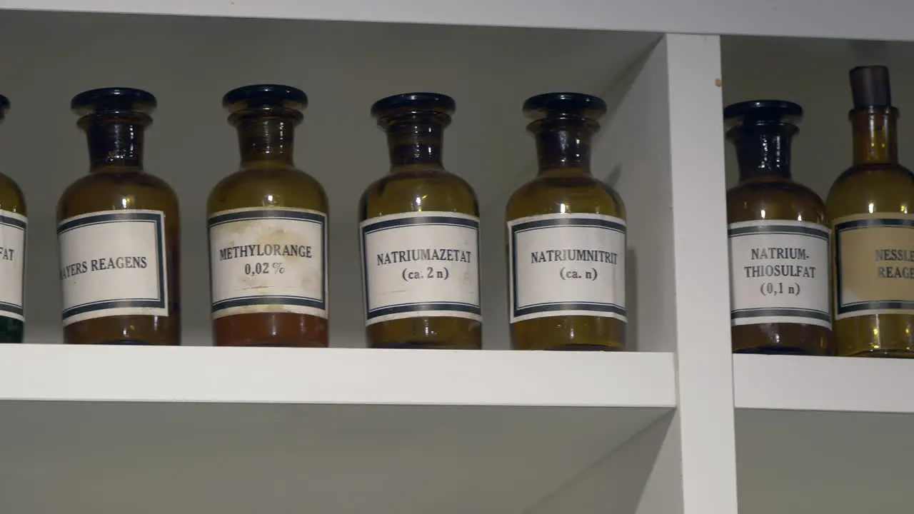 Close up shot of toxic chemicals preserved in retro brown bottles standing in cupboard