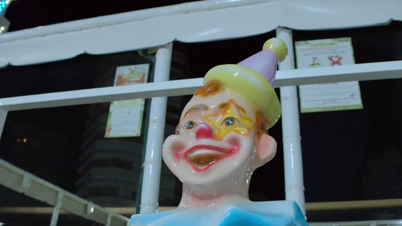 Statue of a laughing clown in outdoor funfair