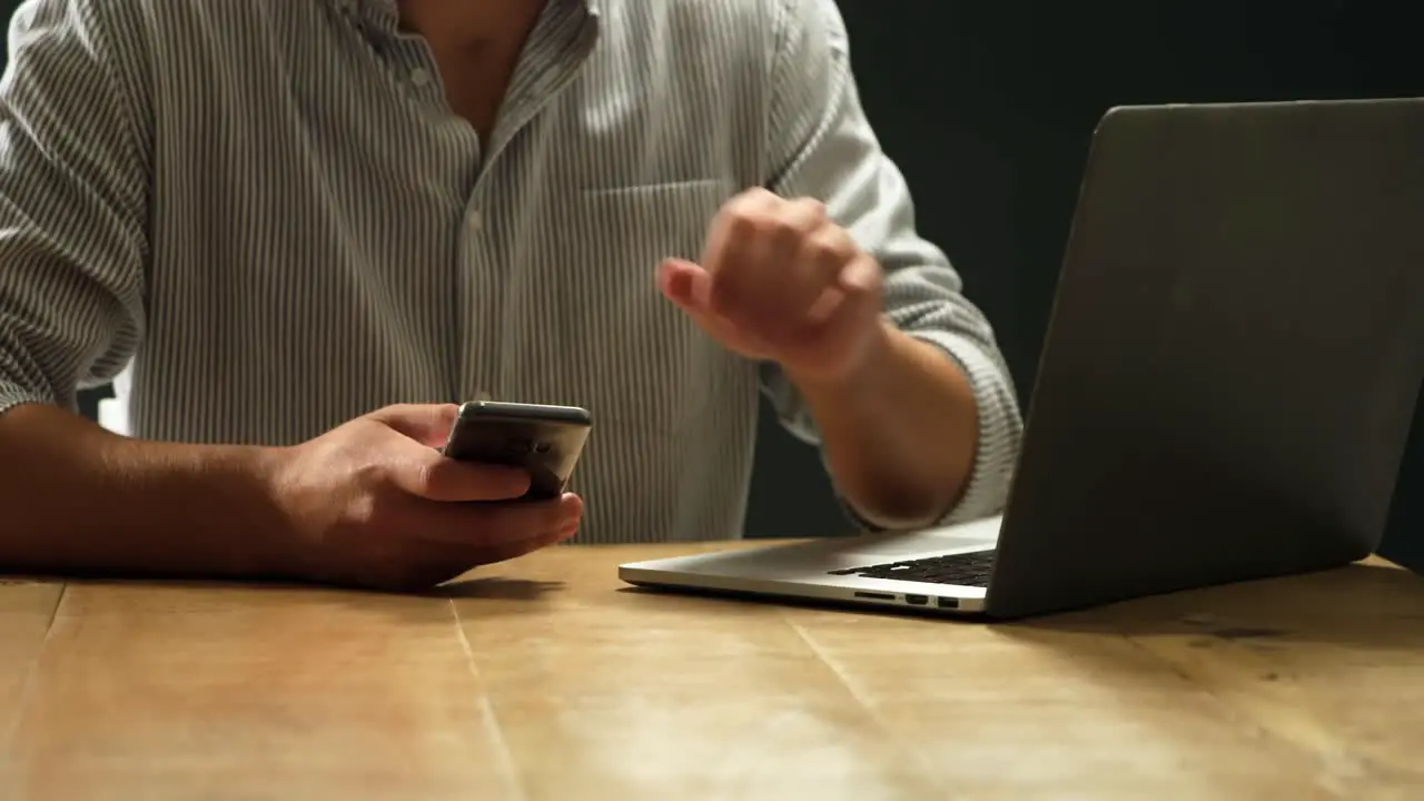 Man using smartphone and laptop