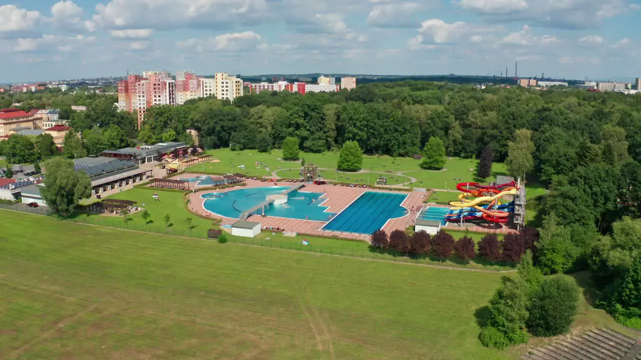 Aerial drone shot of aqupark in the middle of city with pools and water slides during summer