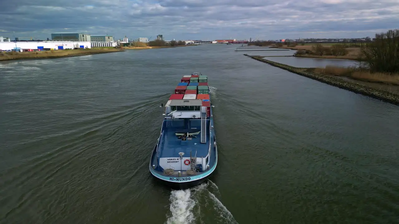 Aerial view following the big cargo ship with containers through the canals of Zwijndrecht The Netherlands