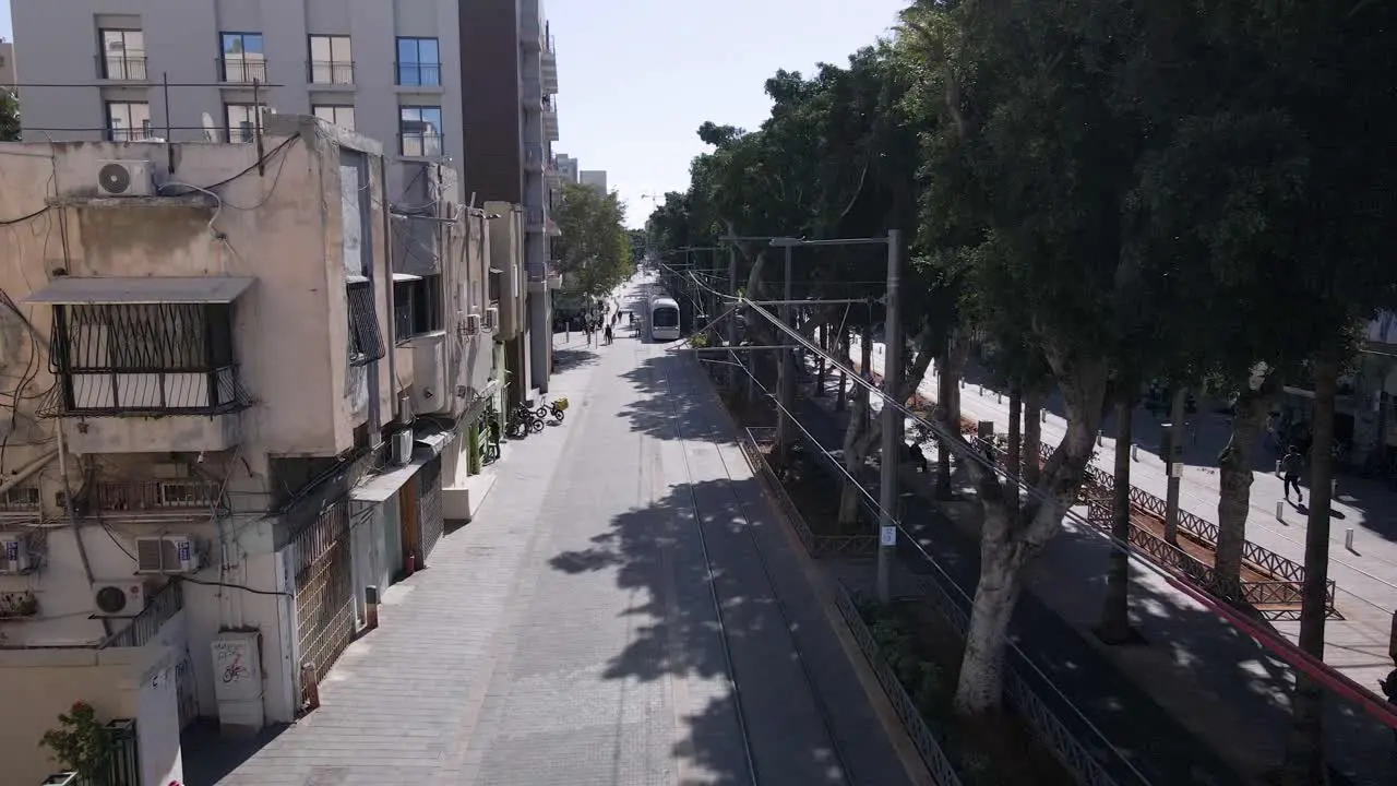 Light rail driving through the city streets aerial view