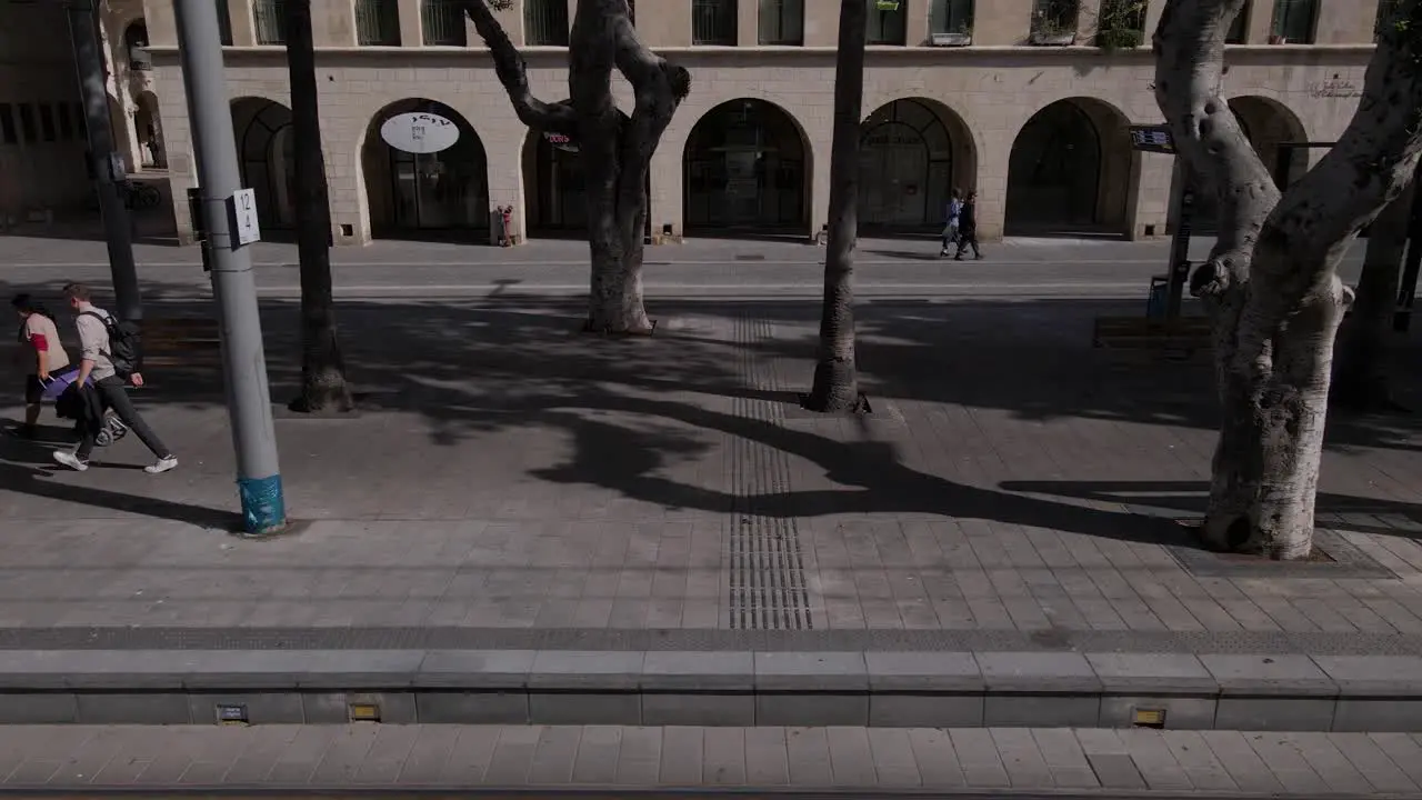 People walking on the tram station in the city establishing shot