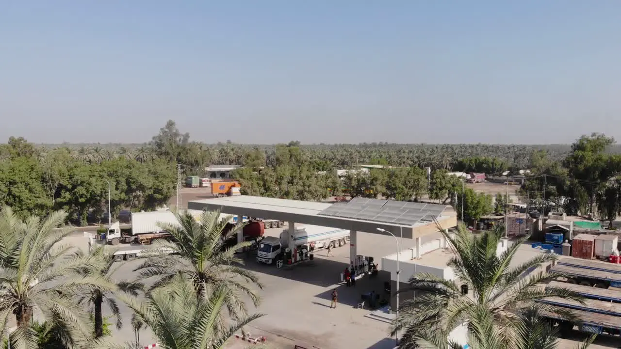 Aerial Flying Over Palm Trees Beside Fuel Gas Station Beside Road In Khairpur