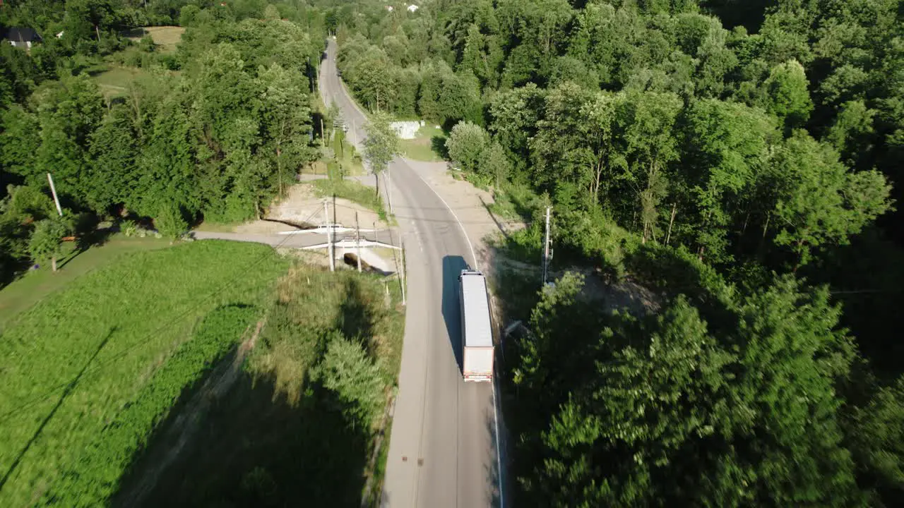 4k Aerial View of Semi Truck Driving Through Countryside Landscape