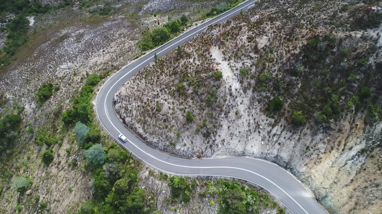 Aerial shot of a car driving on a windy road in Tasmania Australia