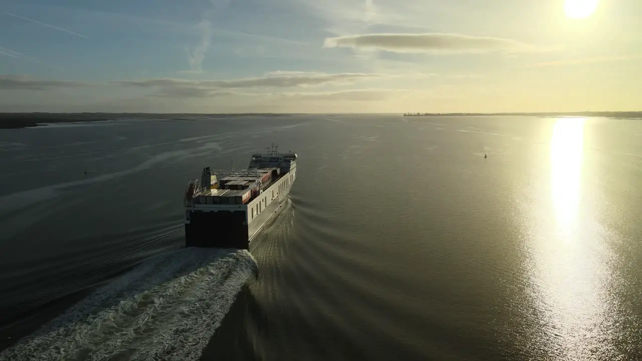 Cargo ship sailing at sunrise on calm waters on Carlingford Lough near Dundalk County Louth Ireland aerial view