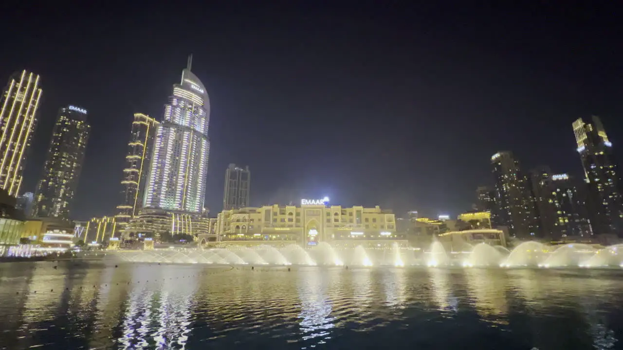 Amazing water show from Dubai fountain seen at night with the cityscape in the background