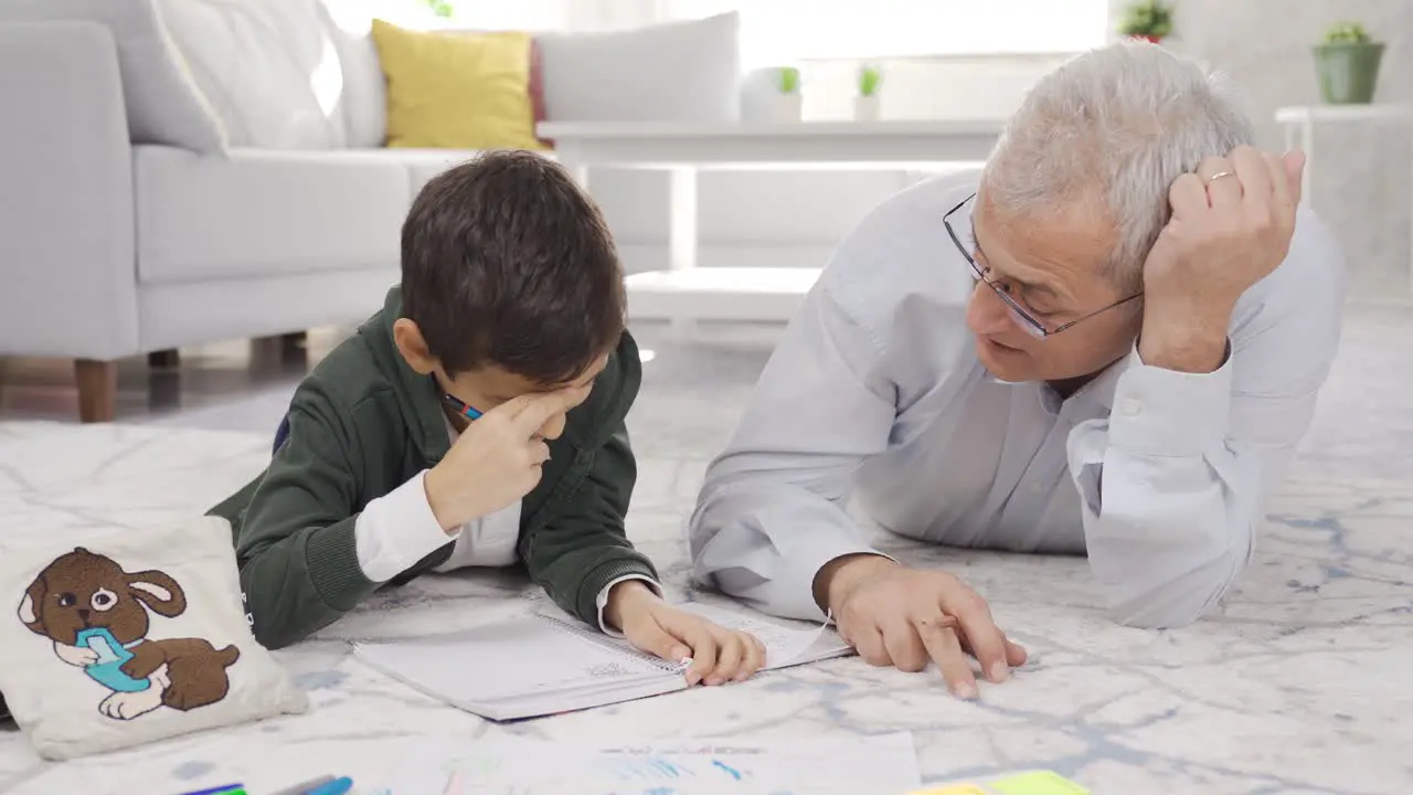 Happy father and son do homework at home and get along well