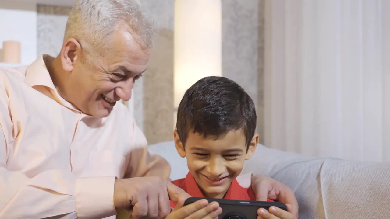 Happy father and son looking at the phone Confused little boy