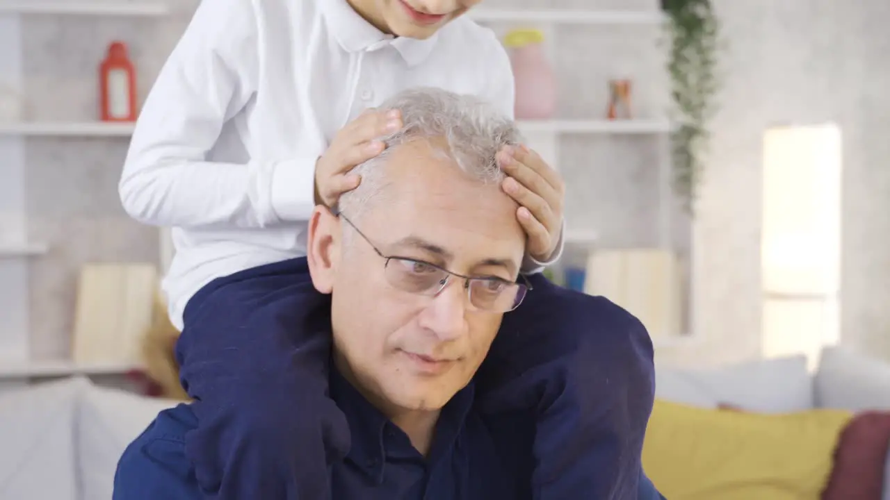 A father works at the table the son interferes in the father's business Parent working from home