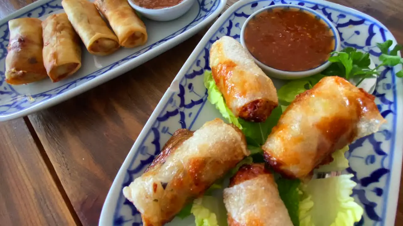 Traditional spring rolls on lettuce with sweet chili sauce in a Thai restaurant delicious asian food 4K shot