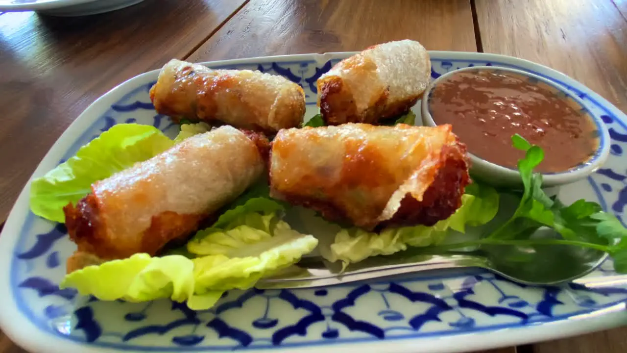 Traditional spring rolls on lettuce with sweet chili sauce in a Thai restaurant tasty asian food 4K shot