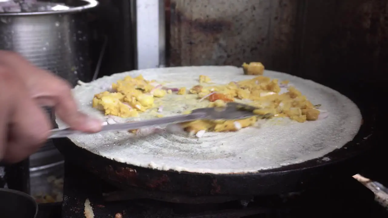 A street food maker prepares the South Indian food Dhosa