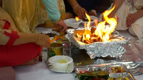 Worshippers Putting Ghee And Offerings Onto Flames Of Fire During Hindu Havan Ceremony