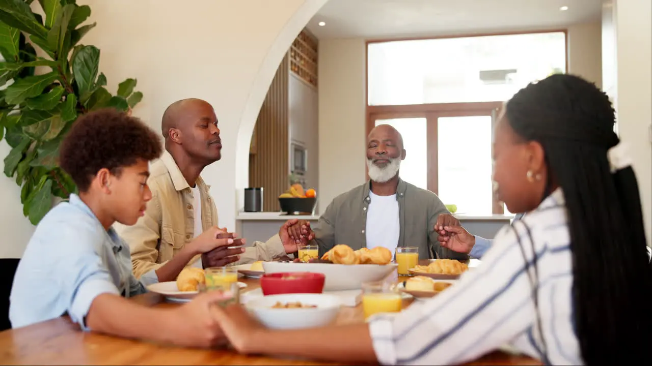 Black family praying and dinner in home