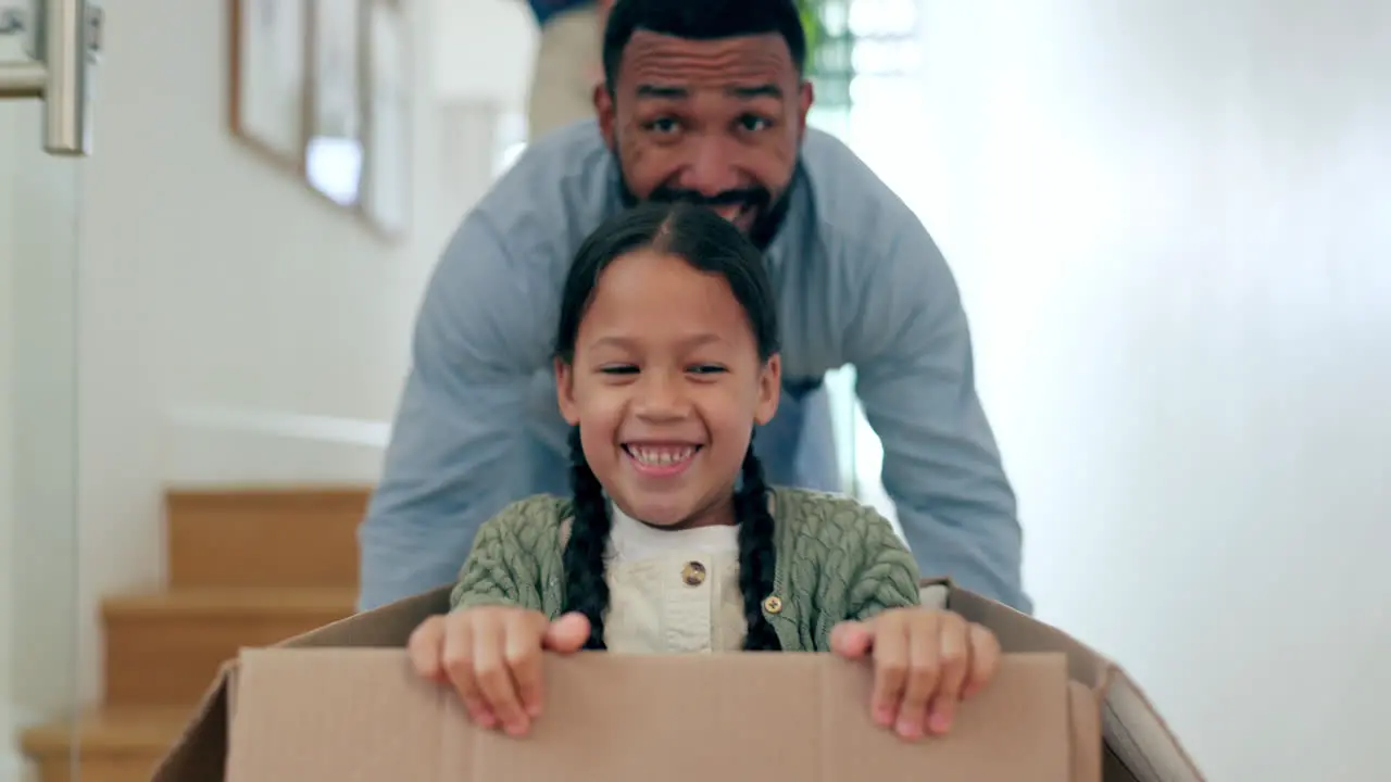 Happy family moving in new home pushing box