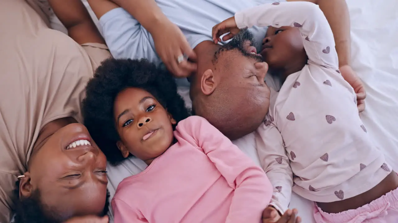 Happy relaxing and black family having fun in bed