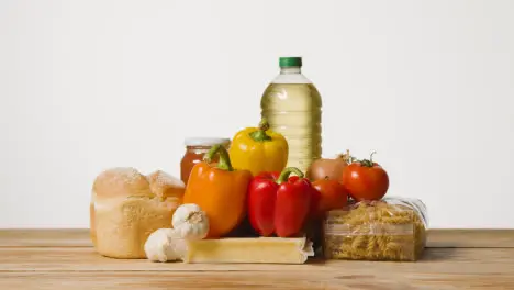 Studio Shot Of Basic Food Items On Wooden Surface And White Background