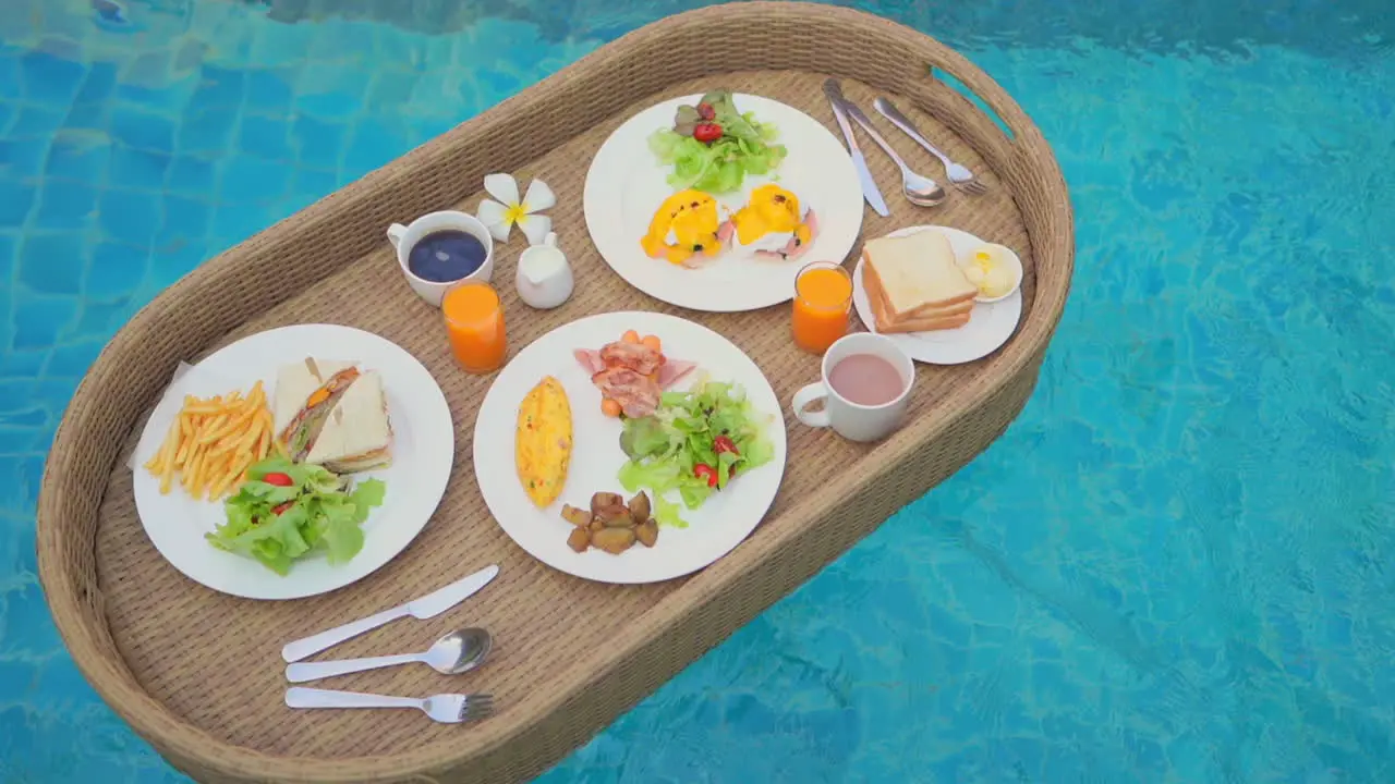 Luxury floating snacks tray on pool transparent water dishes drinks