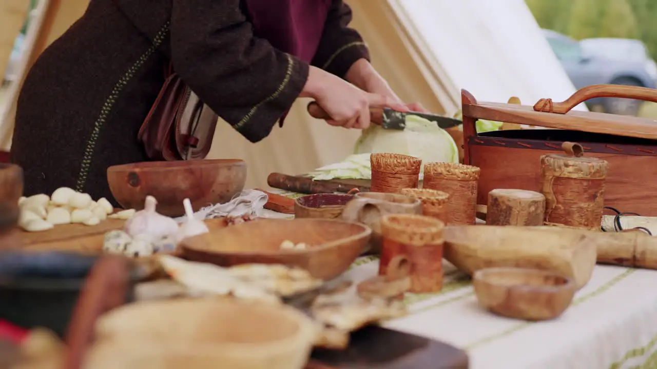 Close up of a woman in medieval costume cutting the cabbage to prepare historical dish like centuries before