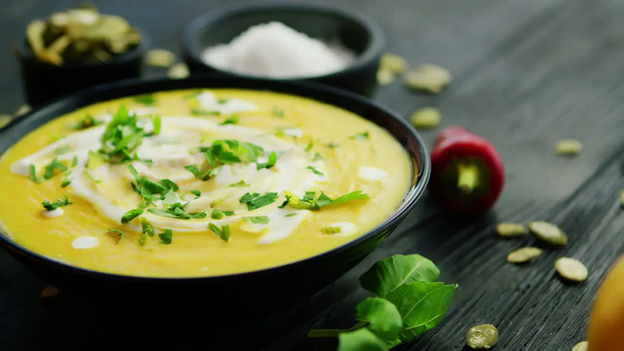 Pumpkin soup in bowl sprinkled with herbs