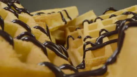 Sliding Extreme Close Up Shot of Chocolate Sauce Pouring Onto Waffles