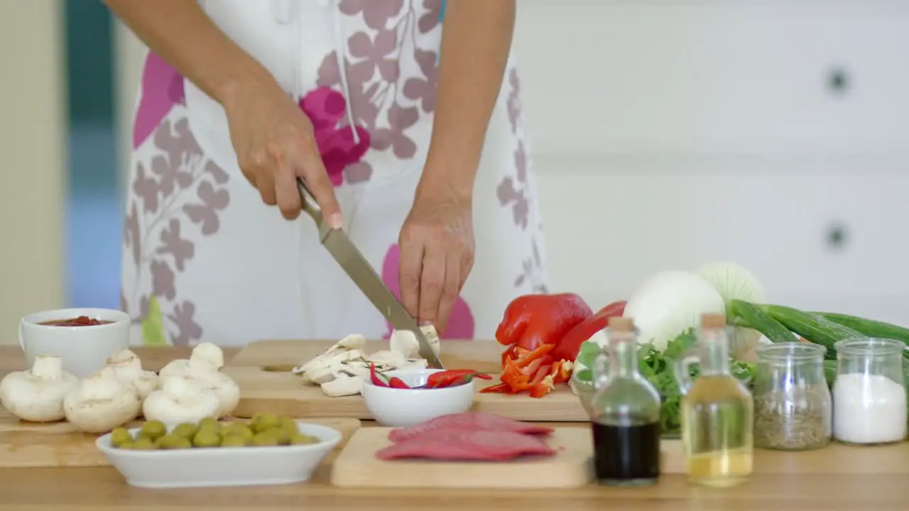 Housewife preparing dinner slicing fresh mushrooms