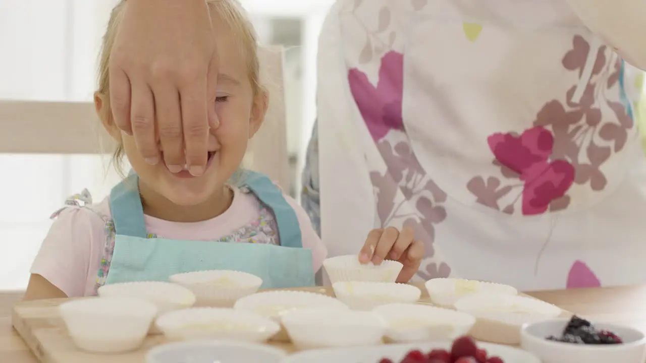 Smiling girl with muffin holders in front of her