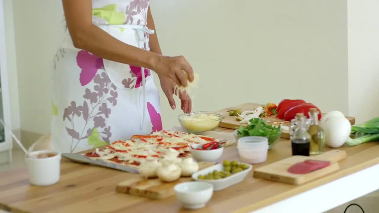 Woman preparing a homemade pizza in the kitchen