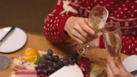 Panning Shot of Table with Food Spread as Two People Bring Their Champagne Glasses Together