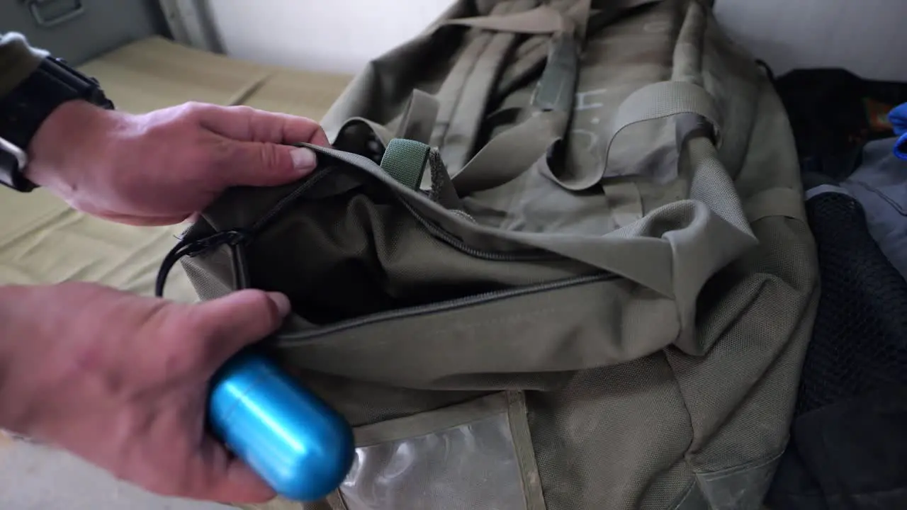 Soldier putting practice grenade in and out of duffel bag close up