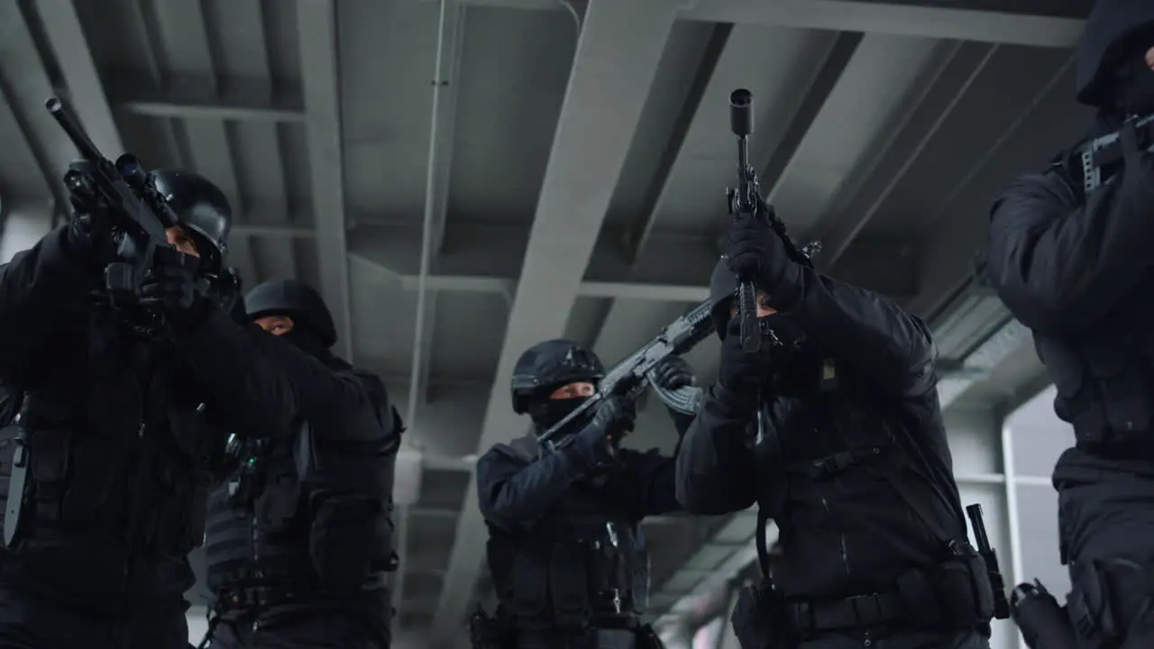 Special ops police team protecting urban building with assault rifles