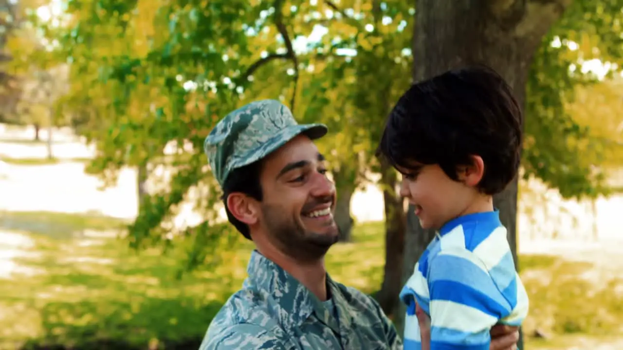 Army soldier lifting boy 