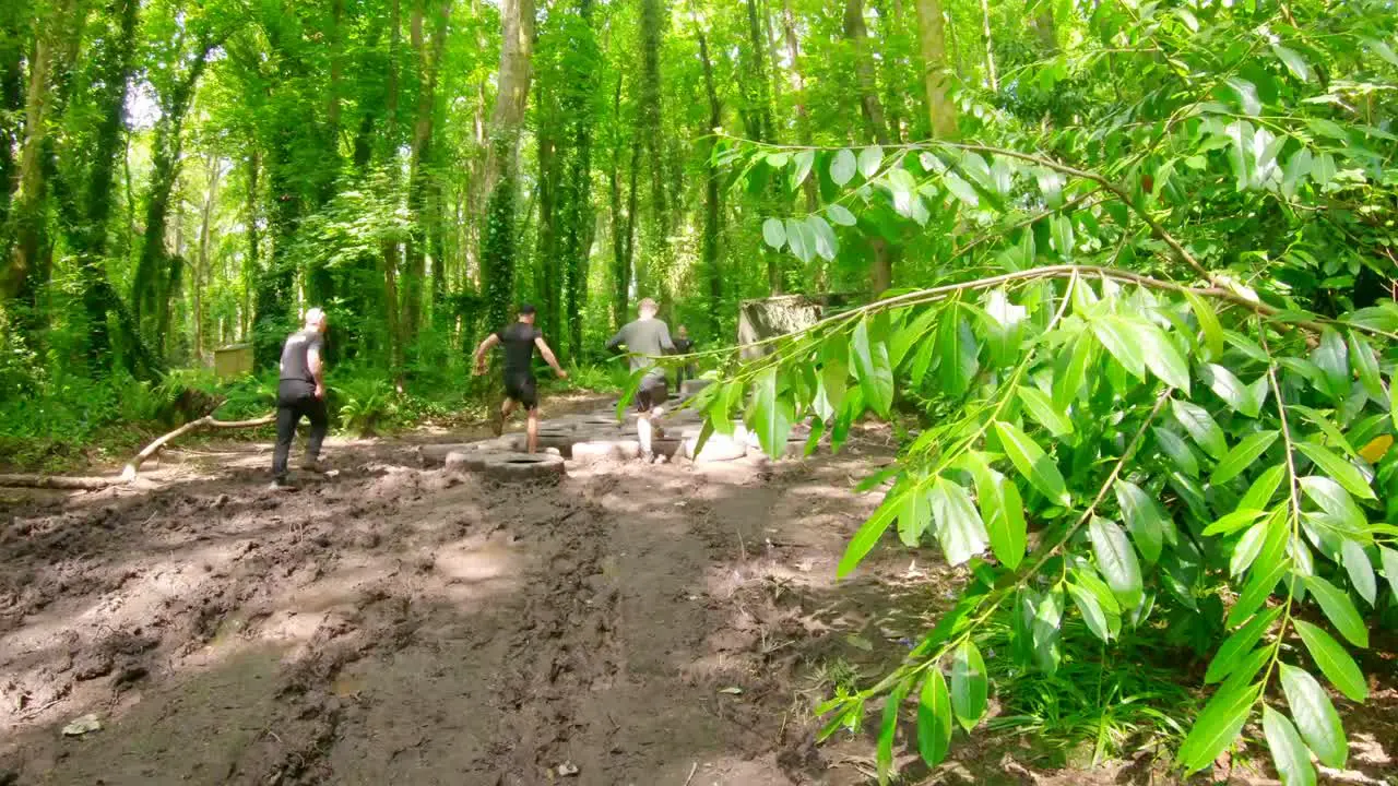 Fit men training over tyres obstacle course 4k