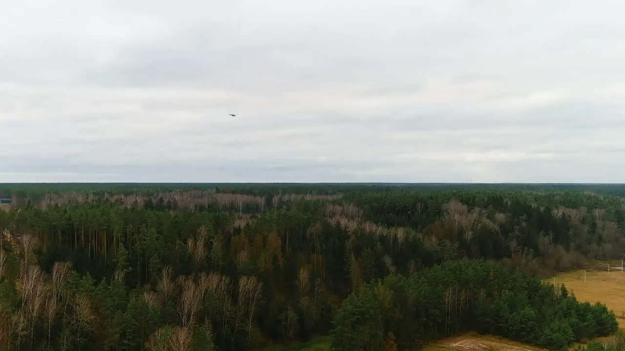 Mi-24 helicopter flying above woodlands of Ukraine aerial view