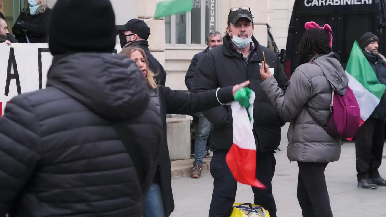 Angry Woman With Italian Flag Shouts To Protest Against The Government With Crowd And Carabinieri In The Background At Piazza XXV Aprile In Milan Italy