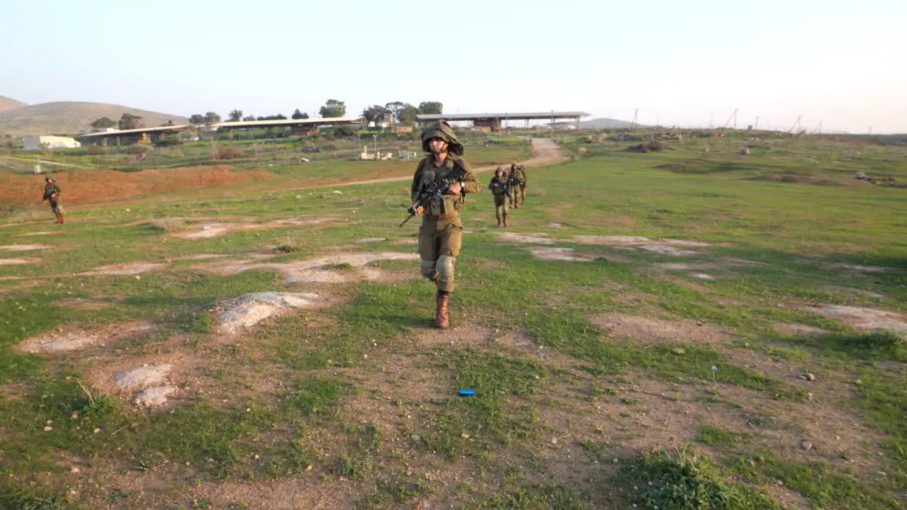 Soldiers walking on the field and picking up practice grenade