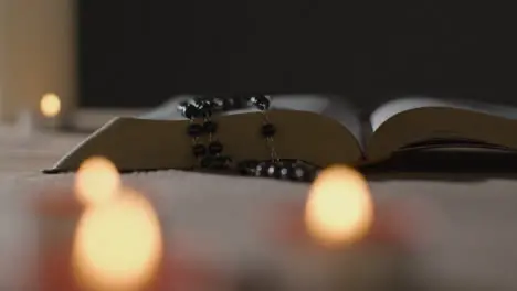 Tracking Shot of Burning Candles Around a Holy Bible and a Crucifix