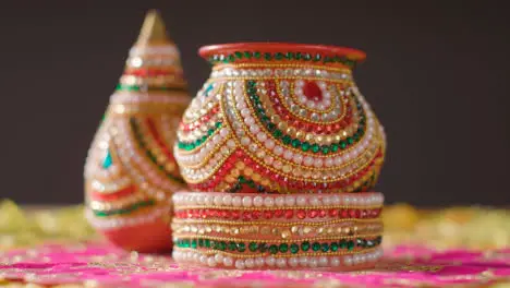 Hand With Traditional Coconut Pots On Table Decorated For Celebrating Festival Of Diwali