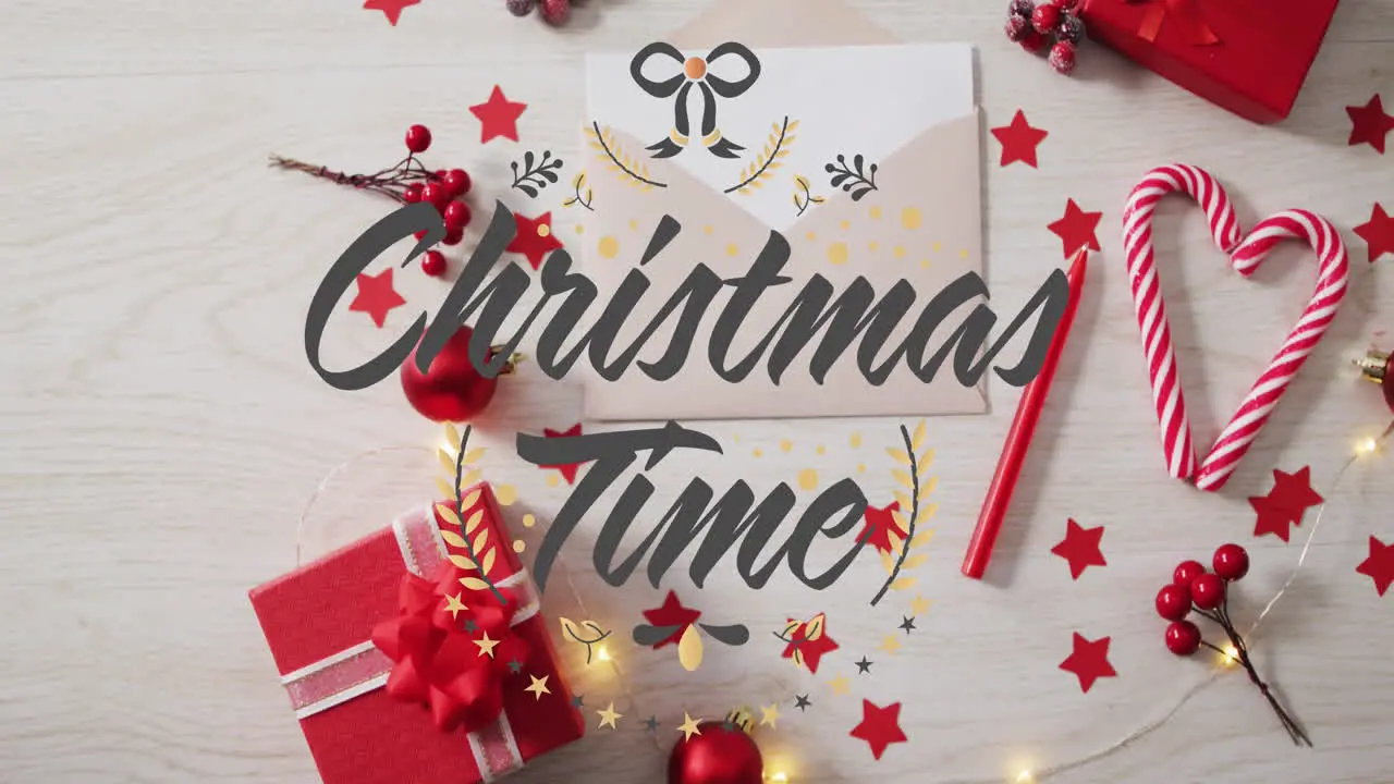 Animation of christmas time text over christmas decorations gifts candlies on table