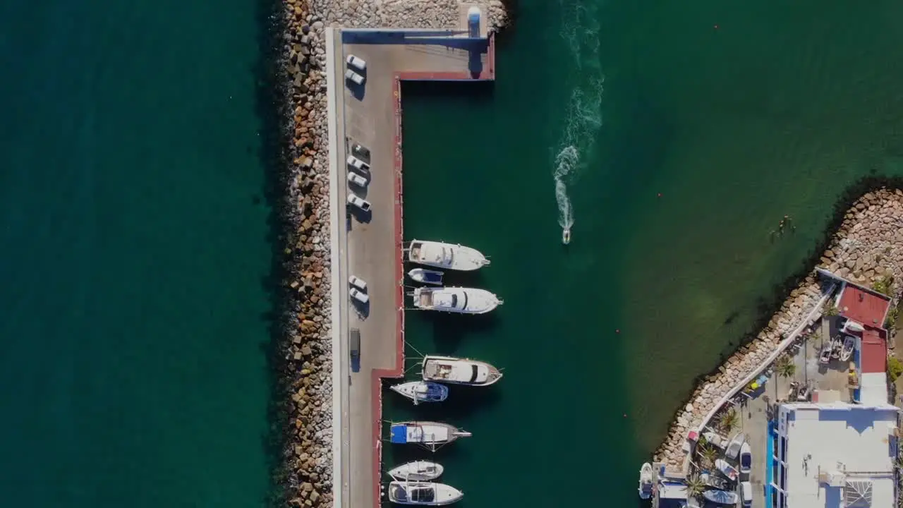 Drone shot rising over the entrance of a marina in Spain