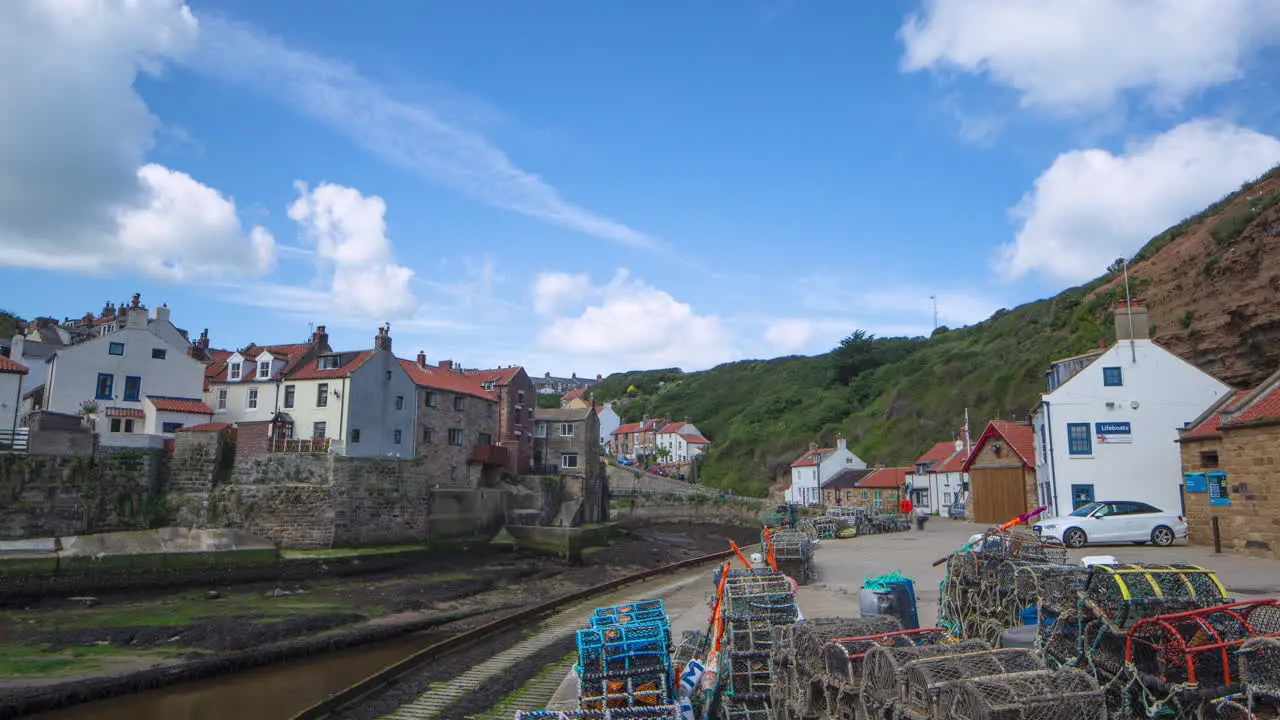 Staithes harbourside timelapse in summer with scudding clouds and bright sun