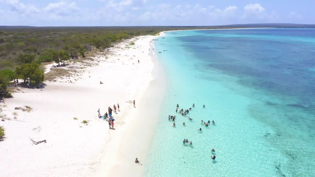 Tourists enjoy crystal clear turquoise waters of Bahia de Las Aguilas