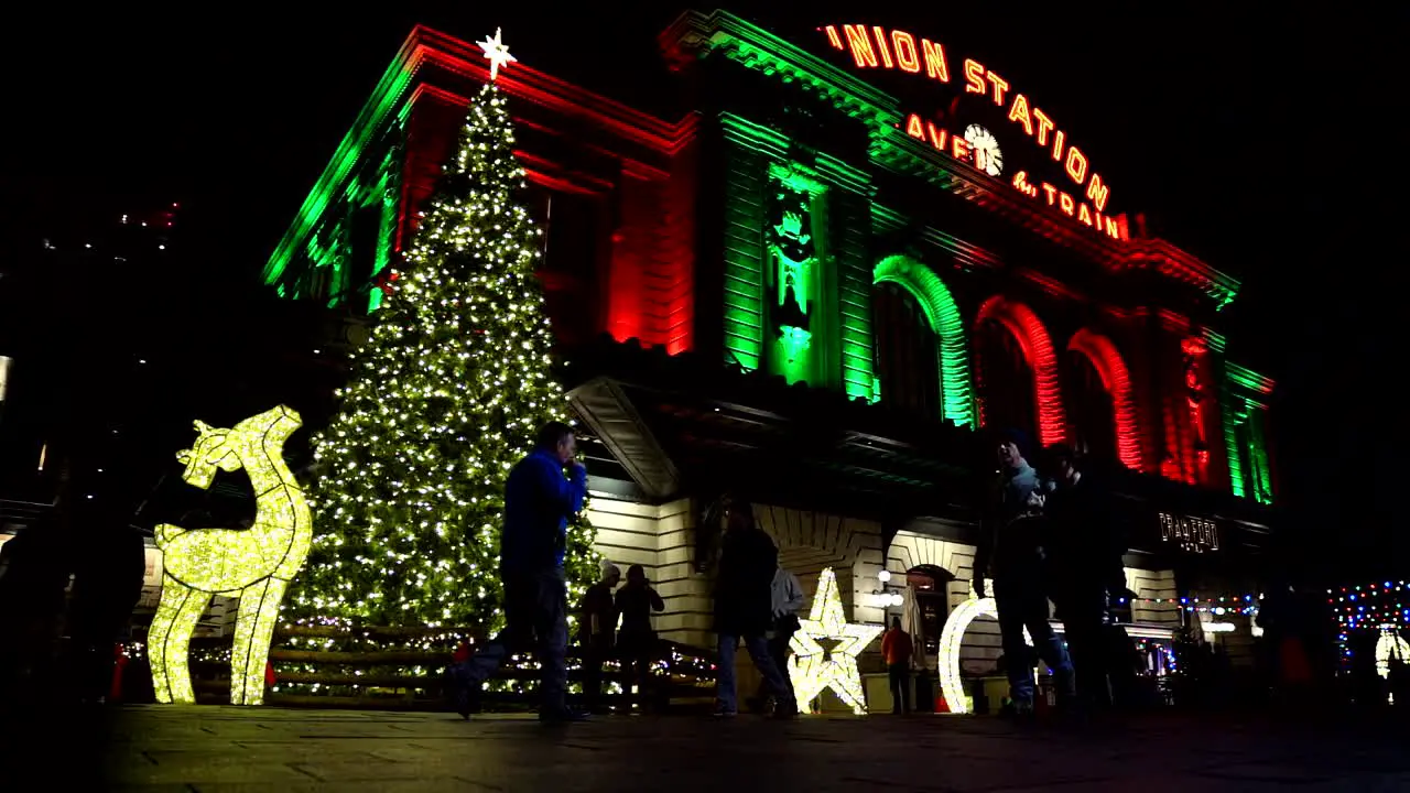 People walking in front of holiday lights decoration in slow motion