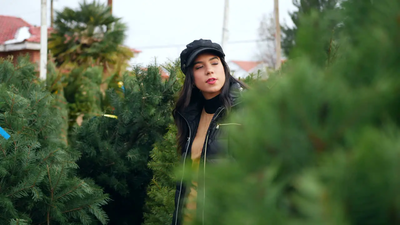 A woman shopping for holiday decorations on a Christmas tree farm lot