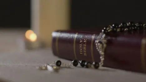 Tracking Shot of Candles Lit around a Holy Bible and a Crucifix