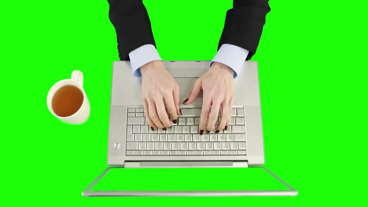 Overview of businesswoman using laptop and holding a coffee cup