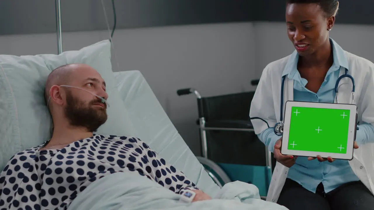 Afro american doctor in uniform discussing with sick man about sickness recovery treatment